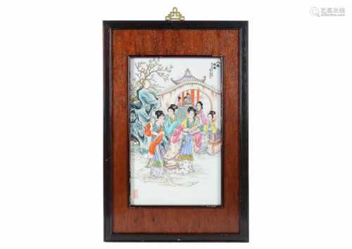 A polychrome porcelain plaque in wooden frame, depicting ladies, a pagoda en characters. Made in