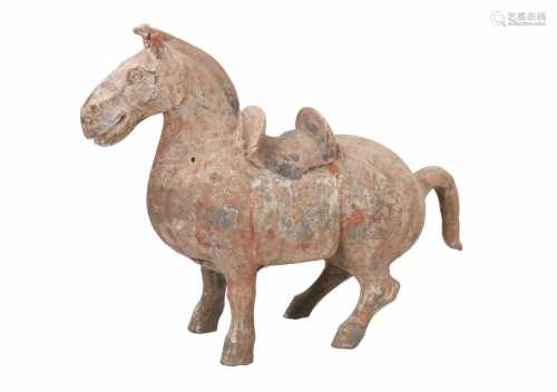 A grey earthenware sculpture of a horse. China, early western Han or later. H. 29,5 cm. L. 36 cm.