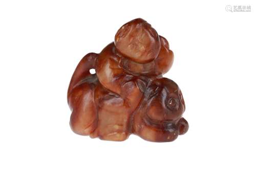 A brown jade sculpture of a figure riding a mythical animal. China, Ming or earlier. H. 4 cm.