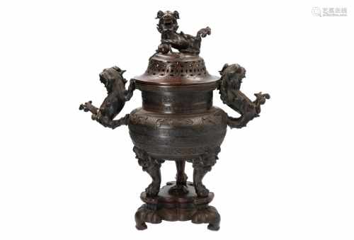 A bronze incense burner on wooden base in organic fungus shape. The handles in the shape of Fo-dogs.