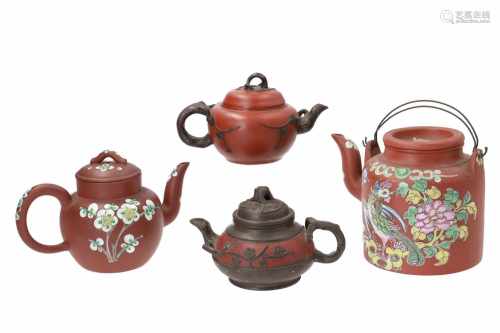 Lot of two Yixing teapots, decorated with flowers in relief. With knob, handle and spout in the