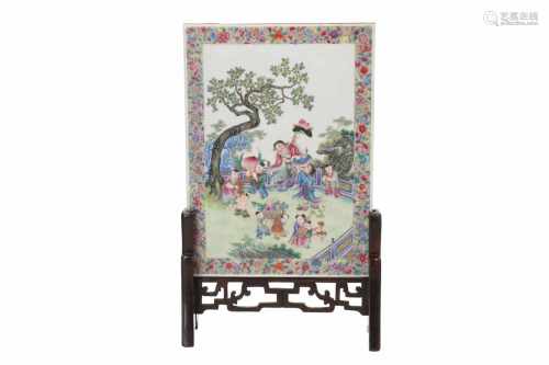 A polychrome porcelain table screen in wooden stand, depicting figures in a garden. Unmarked. China,