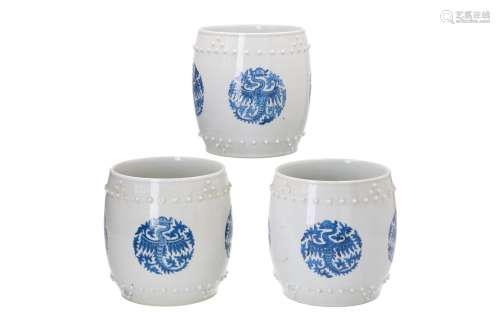 A set of three blue and white round porcelain cachepots, decorated with phoenix and knobs in relief.