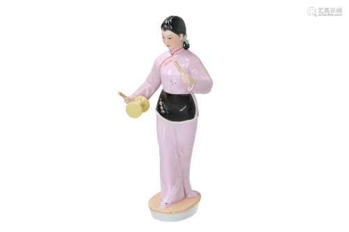 A polychrome porcelain sculpture depicting a lady playing with a diabolo. Marked. China, 20th