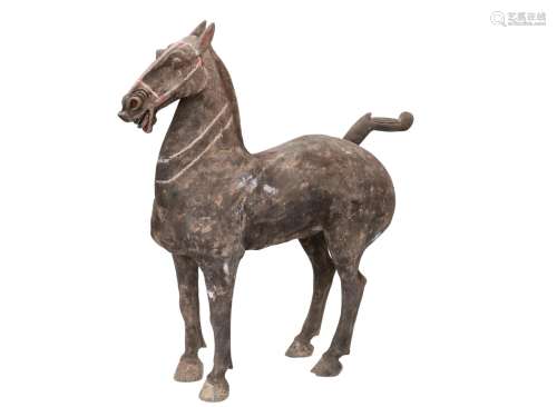 A gray pottery sculpture of a black painted horse. China, early western Han, 206 BC - AD 8 or later.
