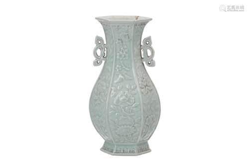 A celadon porcelain vase with two handles, decorated in relief with flowers. Marked with blind