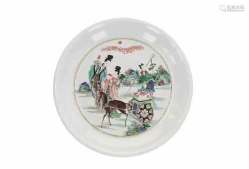 A famille verte porcelain charger, decorated with figures in a landscape with deer pulling a cart.