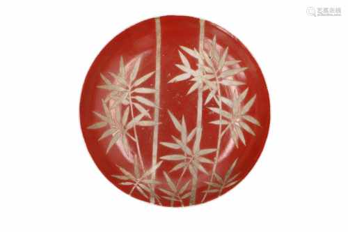 A polychrome porcelain deep dish, the front decorated with bamboo in white on a coral red fond.