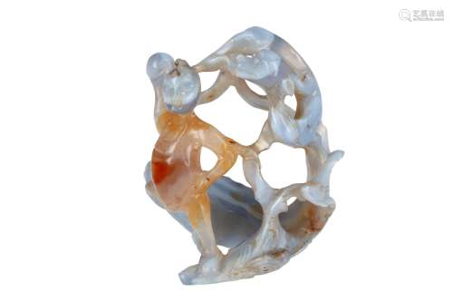 An agate sculpture of a figure holding a pearl, chased by a qilin standing on a carp. China, Qing.