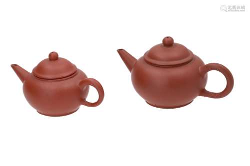 A lot of two round Yixing teapots. One marked with seal marks on base and cover, the other marked