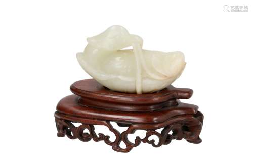 A green jade sculpture of a bird on lotus leaf, on wooden base. China, 18/19th century. L. excl.