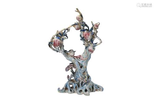 A polychrome porcelain sculpture on wooden base, depicting a peach tree, a bat and a lingzhi.