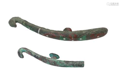 A metal belt hook. L. 10 cm. Weight ca. 58 g. Added a bronze belt hook with polychrome decor. China,