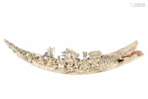 Ivory tusk with on one side a carved decor of a war scene, the other side with birds and trees.