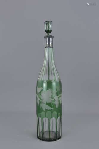 A green wine glass bottle with grape vine design a