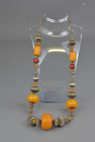 A Tibetan amber resin beaded necklace with silver-