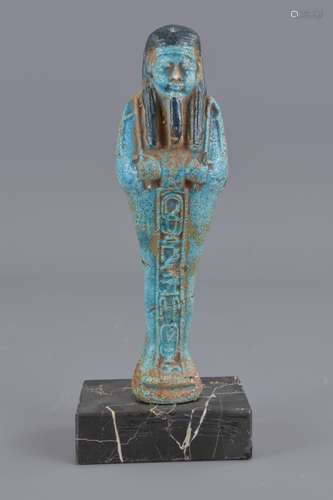 An Egyptian blue faience figure on marbel stand. 1