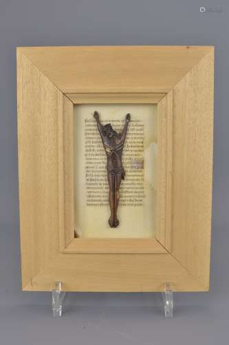 A bone crucifix carving on paper manuscripyt page.