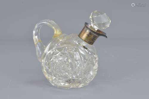 A cut glass vigegar bottle with mounted silver col