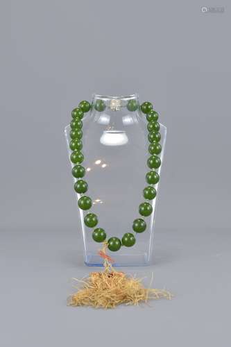 A green stone, possibly nephrite jade beaded neckl