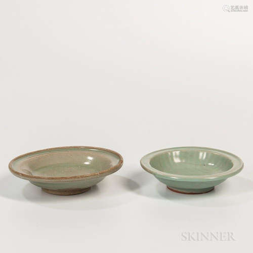 Two Celadon-glazed Dishes, China, Song dynasty style, one plain with rolled mouth rim, resting on a raised bisque foot ring, the other