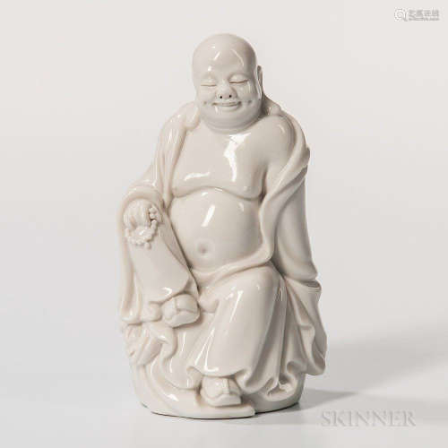 Small Dehua White Figure of Budai, China, Qing dynasty, seated with his right leg raised and left down, a string of prayer beads in his