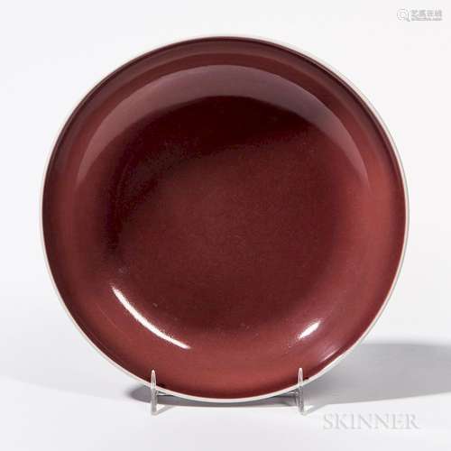 Copper Red-glazed Dish, China, 18th century, with shallow, rounded sides rising from a short tapering foot, the rich red glaze thinning