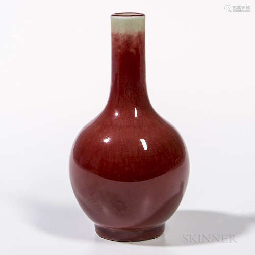 Small Flambe-glazed Bottle Vase, China, 19th/20th century, bulbous form with long neck, on a raised straight foot, the red glaze thinni