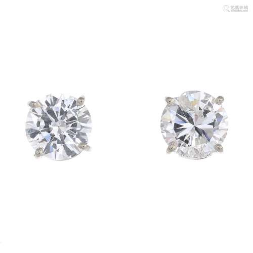 A pair of brilliant-cut diamond stud earrings.