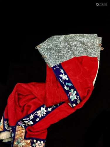 Une jupe plissée en soie rouge bordée de rinceaux ...;