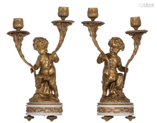 A pair of gilt bronze candlesticks on a white marb…