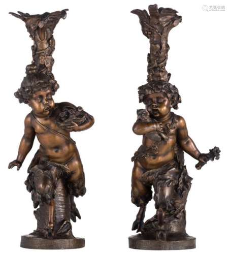 A pair of patinated bronze candlesticks depicting …