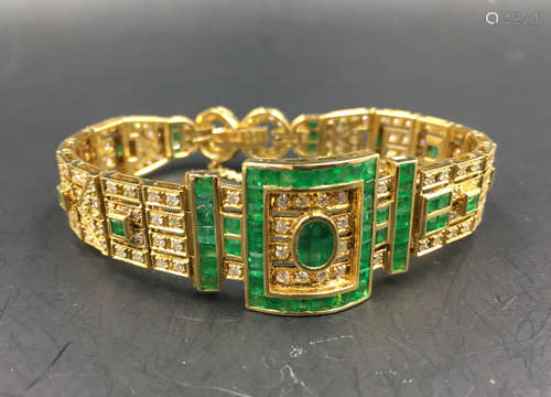 A K-GOLD BANGLE INLAID EMERALD AND DIAMOND