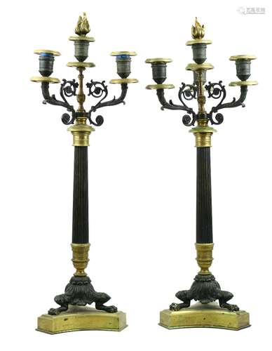 Pair of French Empire style bronze and brass candelabra, each having three lights, above a reeded