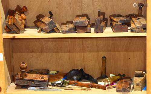 Two shelves of assorted antique wood working tools, comprising a various smoothing planes;