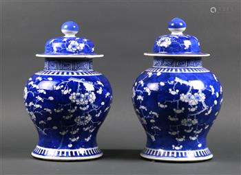 Pair of Chinese underglaze blue porcelain lidded jars, featuring prunus on a cracked-ice ground