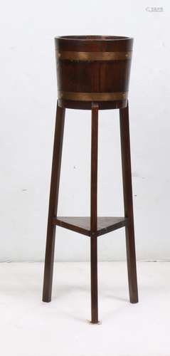 English ice bucked on stand, executed in oak, having copper banding, and rising on outswept legs