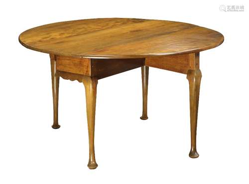 Queen Anne drop leaf table, having an oval top, and rising on cabriole legs terminating on pad feet,