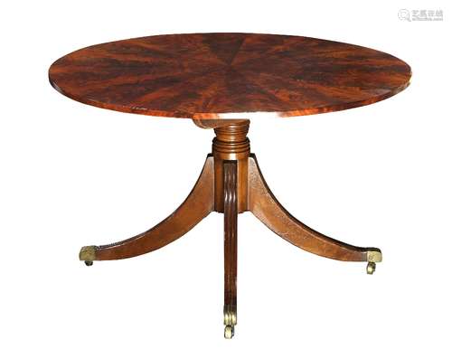 Regency flame mahogany center table, having a circular tilt top, above a baluster form standard, and