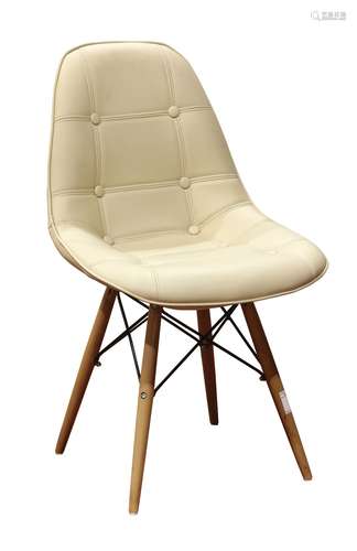 Charles and Ray Eames style side chair, having tufted cream upholstery, and rising on tapered