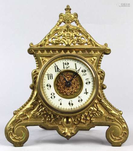 English Rococo style desk clock, having a brass architectural body with a white enamel dial, 10