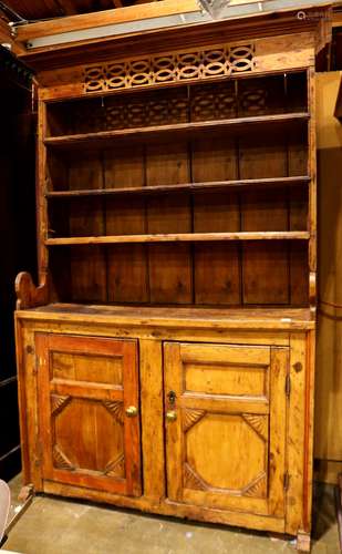 Primitive pine hutch, the pierced cornice above three fitted shelves and two lower cabinet doors,