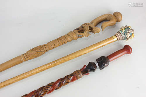 Three ethnographic walking sticks, to include one with composite handle formed as a dragon, and