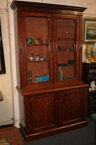 A Victorian mahogany bookcase, the cornice with decorative carved frieze above two glazed panel