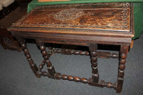 A Victorian carved oak side table, the top with central medallion and scroll surround, on bobbin