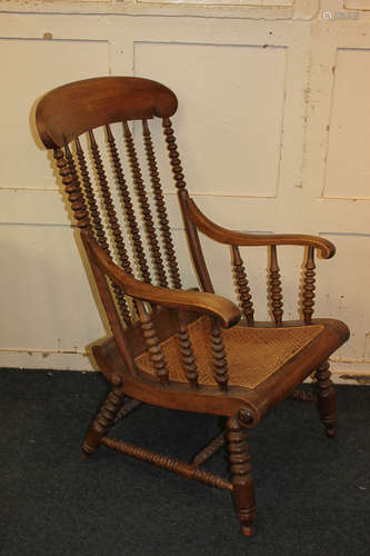 A kitchen style chair with curved rush seat and scroll arms, on bobbin turned supports