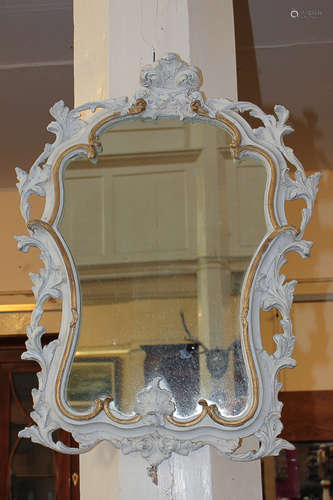 A French carved wood and gesso wall mirror with painted white and gilt scrolling pierced frame, 62cm