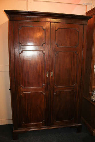 A Continental mahogany wardrobe with moulded cornice, twin panelled doors, on bracket base, 120cm