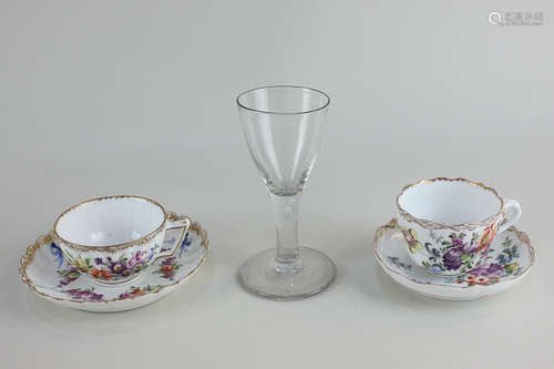 A 19th century German porcelain teacup and saucer with hand painted floral designs and gilt