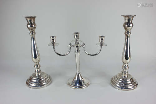 A pair of silver plated column candlesticks together with a two branch candelabra